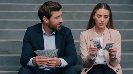 Woman looking at her money next to a man with a lot of money